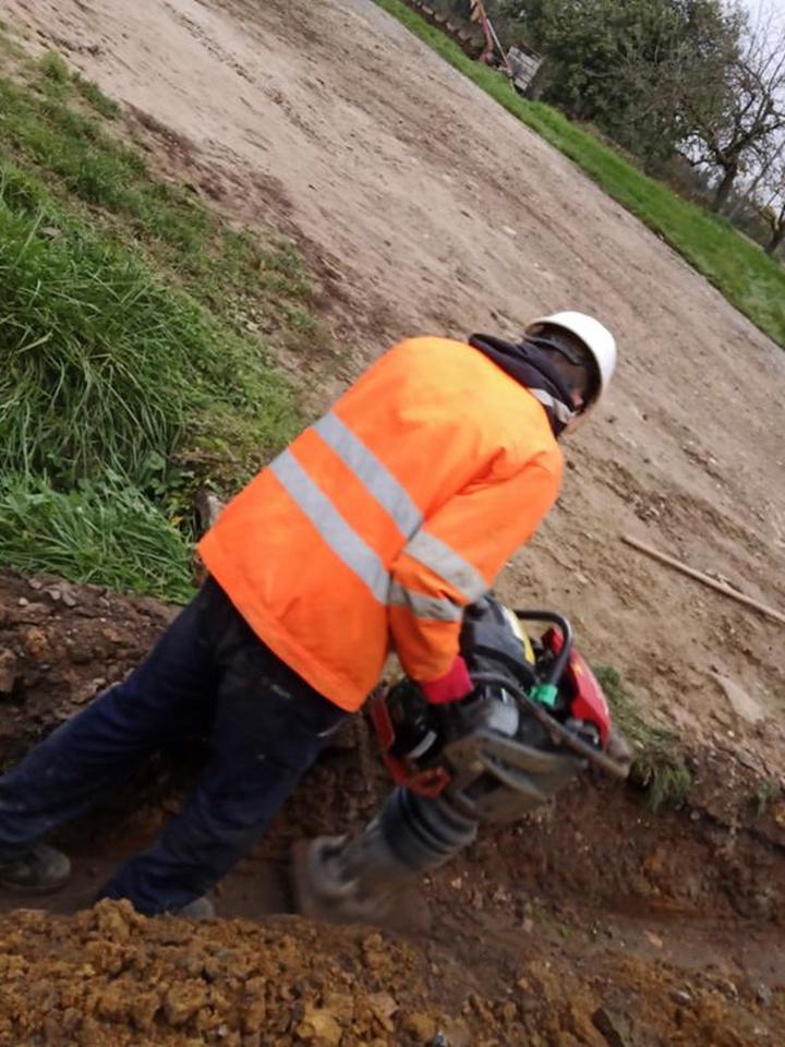 Compactage du remblai à la pilonneuse par un opérateur en EPI
