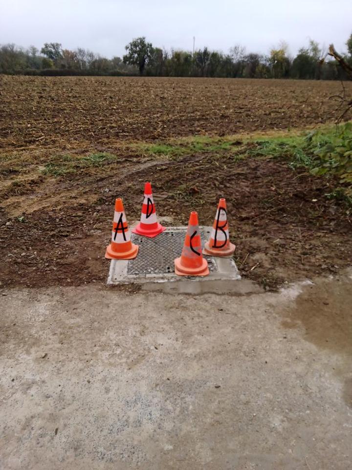 Chambre neuve scellée au béton, balisée par quatre cônes repérés