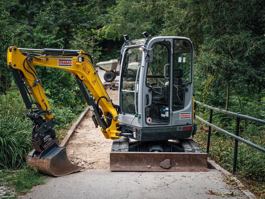 Mini-pelle au travail sur un chemin étroit